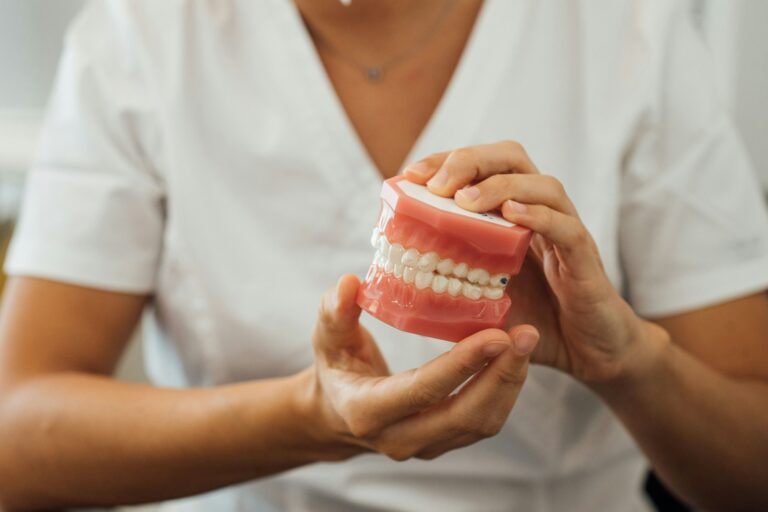 Partial view of a nurse holding dentures in hands