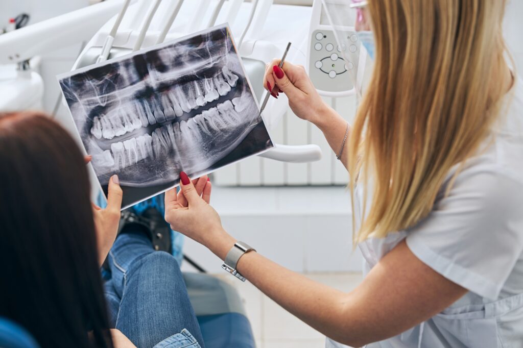 Competent dentist consulting her patient after checkup