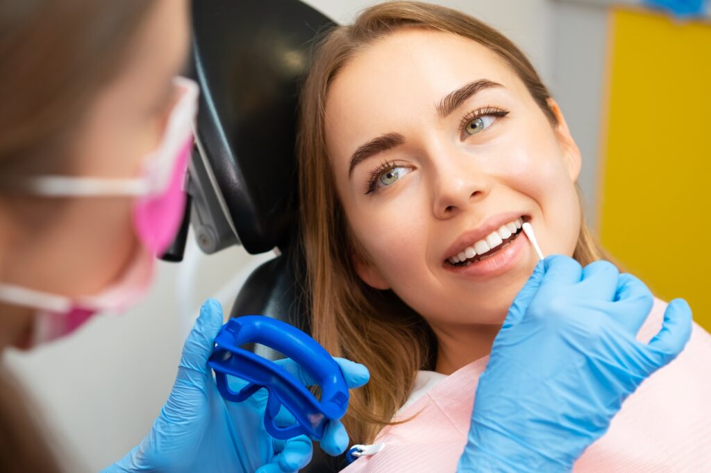 Dentist applies plaque detector on front teeth in clinic